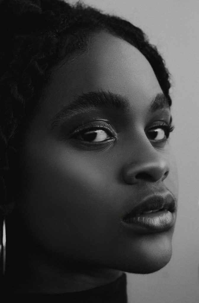 Black and white close-up portrait of a young woman with a focus on beauty and emotion.