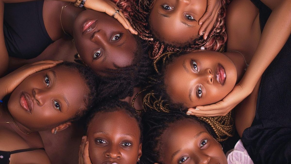 A captivating aerial shot of six diverse women lying together, exuding unity and elegance.